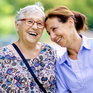 A woman and her elderly mother enjoy time outside together.