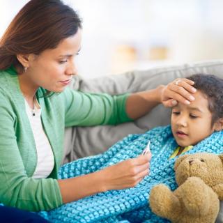 A woman comforts her ill child while while she rests