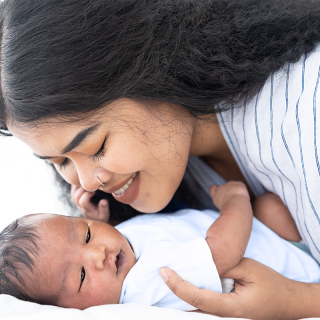 A new mother sweetly cuddles with her newborn baby.