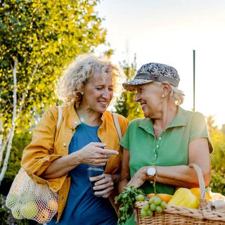 Two older women walking and laughing.